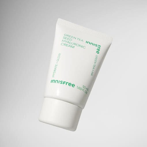 White tube of hydrating green tea seed hyaluronic cream with green text on a simple gray background