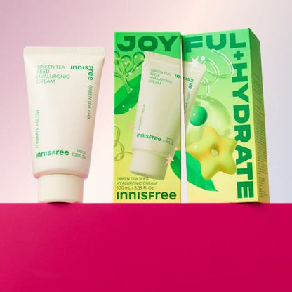 Tube of hydrating green tea cream next to vibrant green box with joyful hydration text and green tea seed graphic