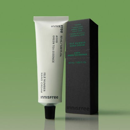 Minimalist tube of hand cream with green tea essence and dark rectangular packaging on green background