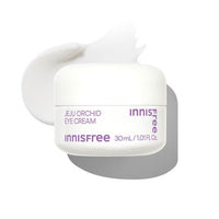 White jar of hydrating orchid eye cream with soft cream texture swatch on a bright white background