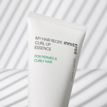 White tube of curl essence for permed and curly hair with subtle striped shadow pattern background