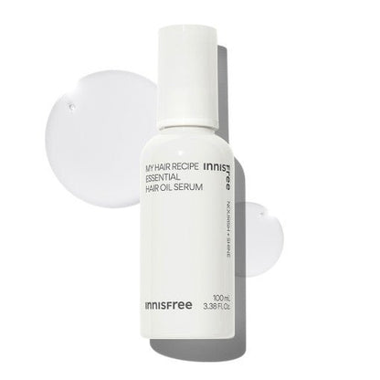White bottle of nourishing hair oil serum with smooth clear liquid drops on a white background