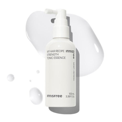 White pump bottle of hair tonic essence with clear serum drops and smooth liquid swatch on white background
