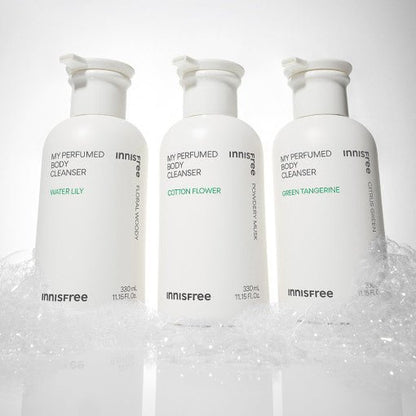 Three white pump bottles of innisfree perfumed body cleanser with foamy bubbles at the base on a white background