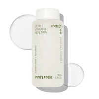 Matte white bottle of Olive Vitamin E Real Skin with clear lotion drops on a bright white background