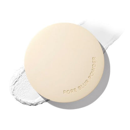 Round beige compact of pore blur powder with smooth matte finish and subtle embossed lettering on white background