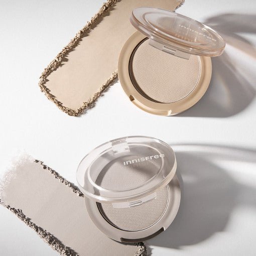 Two open powder compacts with natural-toned shading powders and smooth texture on a white surface