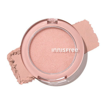 Compact of soft pink highlighter with subtle shimmer and natural glow effect on white background