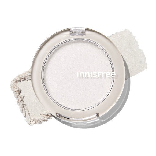 Compact round container of sheer pale highlighter powder with soft glow and natural radiance effect on white surface