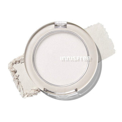 Compact round container of sheer pale highlighter powder with soft glow and natural radiance effect on white surface