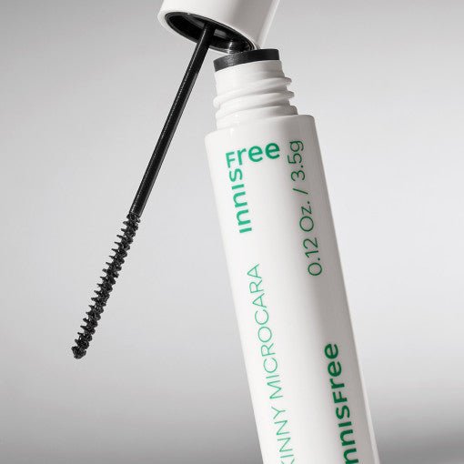 White tube of brown mascara with slender brush applicator designed for precision application on light background
