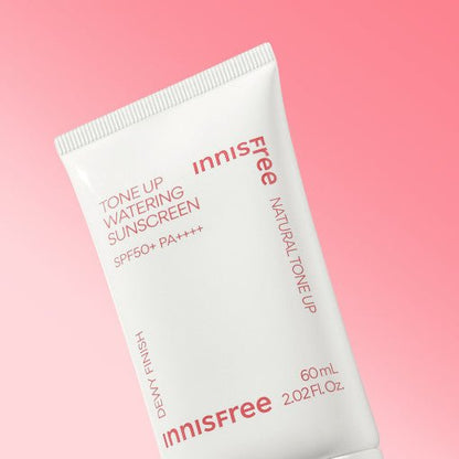White tube of tone-up watery sunscreen with SPF50+ PA++++ featuring natural dewy finish on soft pink background