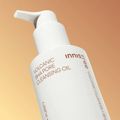White pump bottle of pore cleansing oil with volcanic BHA formula on warm beige background