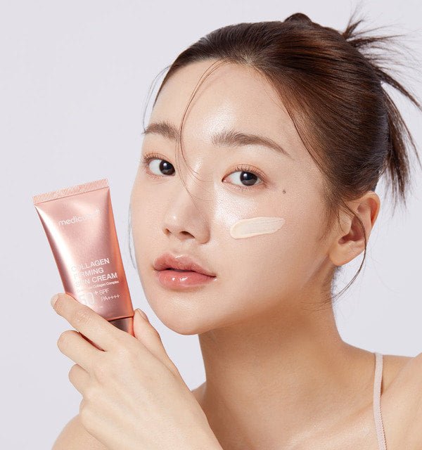 medicube Collagen Firming Sun Cream 50ml held by woman with smooth skin and swatch on cheek for high protection benefits