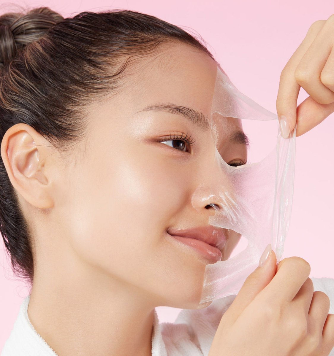 medicube Collagen Night Wrapping Mask 75ml shown lifting translucent mask off smooth, elastic skin with radiant glow