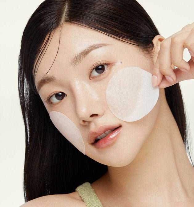 model applying medicube Exosome Cica Calming Pad 150ml/100 Pads on cheeks for gentle exfoliation and soothing care