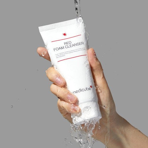 medicube Red Foam Cleanser 230ml held under running water to emphasize deep cleansing effect