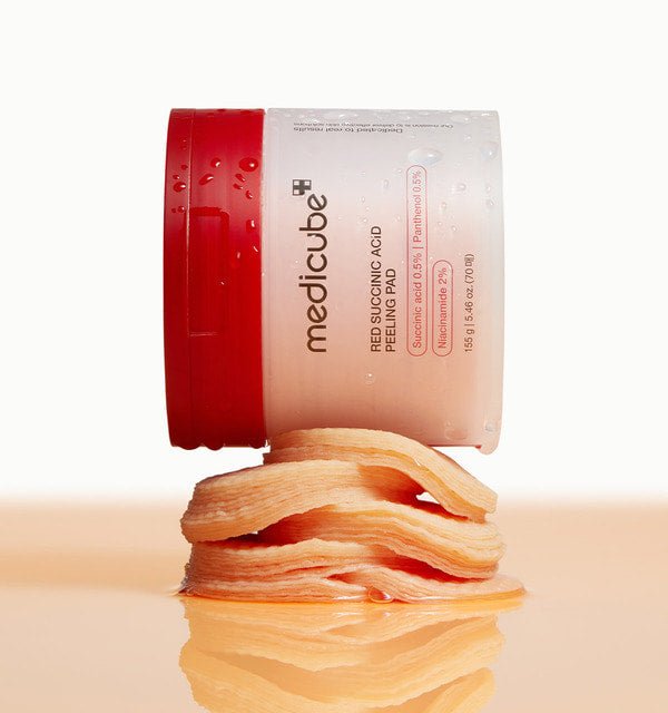 medicube Red Succinic Acid Peeling Pad 155g/70pads container with exfoliating pads stacked below for acne relief care