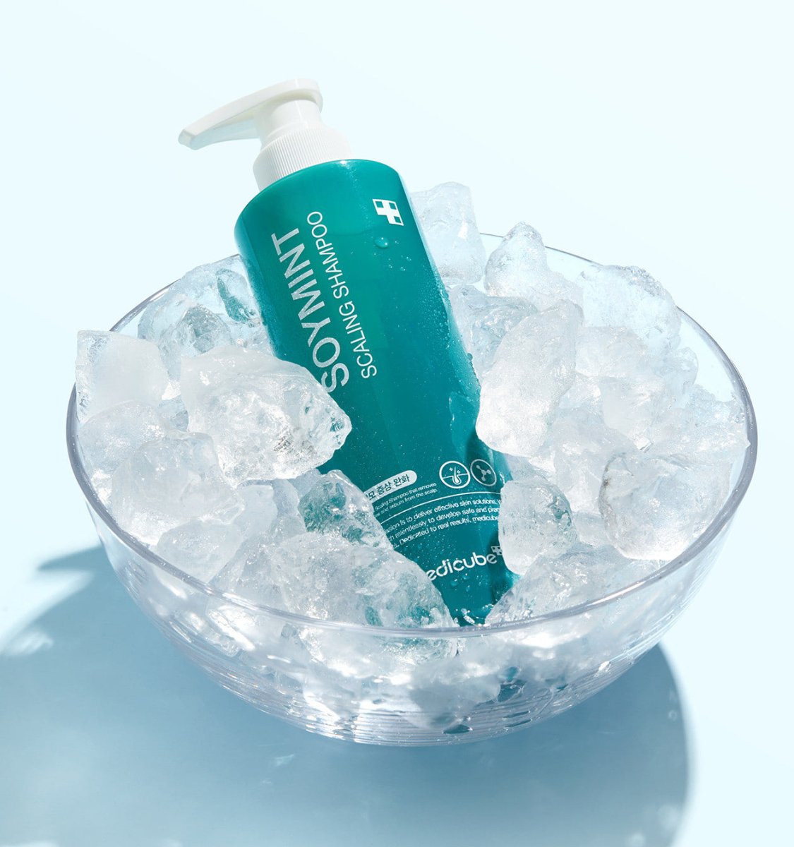 medicube SOYMINT Scaling Shampoo 490ml in teal bottle with pump nestled in clear bowl of refreshing ice cubes