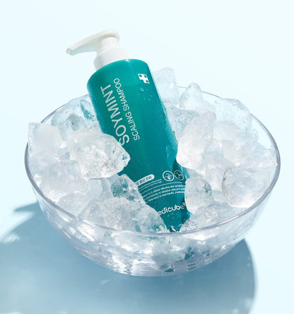 medicube SOYMINT Scaling Shampoo 490ml in teal bottle with pump nestled in clear bowl of refreshing ice cubes