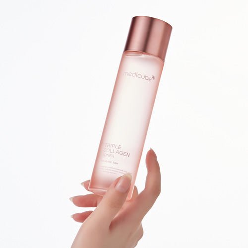 medicube Triple Collagen Toner 4.0 140ml bottle with sleek pink packaging held for deep hydration care benefits