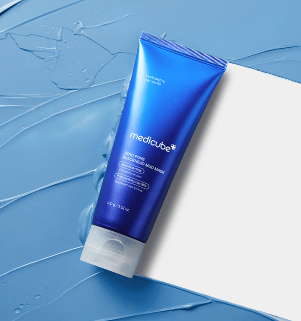 medicube Zero Pore Blackhead Mud Mask 100g in vibrant blue tube placed on textured blue mud background for deep cleansing