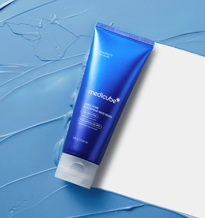 medicube Zero Pore Blackhead Mud Mask 100g in vibrant blue tube placed on textured blue mud background for deep cleansing