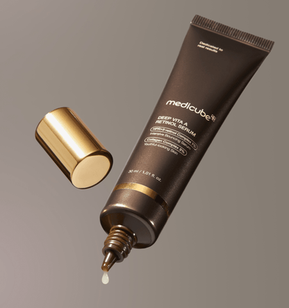 medicube Deep Vita A Retinol Serum 30ml in matte brown tube with gold cap releasing droplet of serum