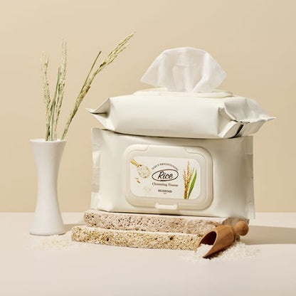 Soft beige packaging of rice cleansing tissues displayed with natural rice stalks and scattered grains on neutral background