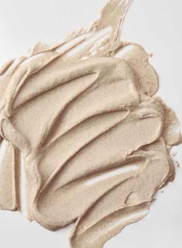 Creamy beige textured mask spread showcasing smooth, radiant skin-enhancing glow with natural ground rice elements