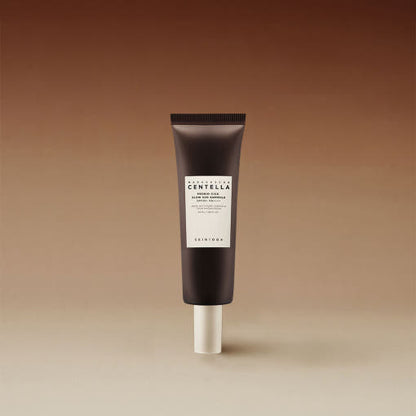 Dark brown tube of glow sun ampoule with SPF 50+ PA++++ for effective UV protection on gradient beige background