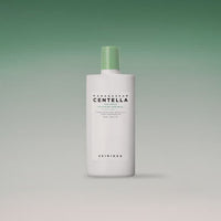 White bottle with green cap of soothing sun milk featuring centella extract and high SPF protection on gradient green background