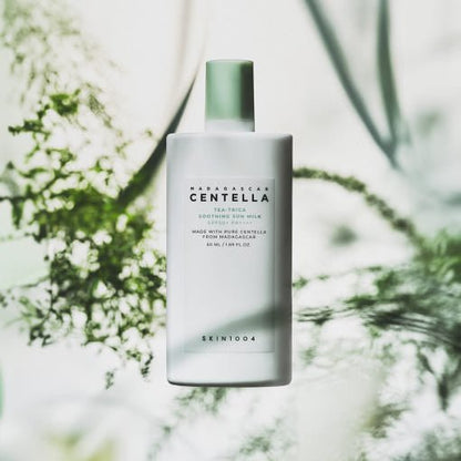 White bottle of soothing sun milk with green cap and subtle botanical shadows in soft natural light