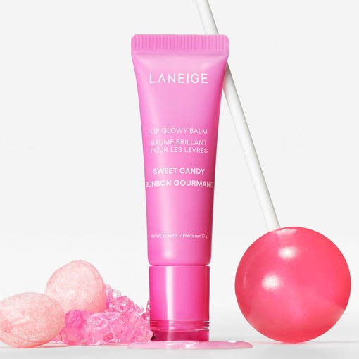 LANEIGE Lip Glowy Balm 10g in pink tube with sweet candy scent and rich moisture next to a glossy pink lollipop