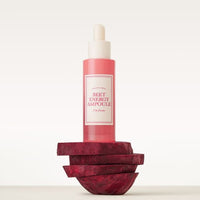 Pink glass dropper bottle of hydrating ampoule balanced on stacked beetroot slices against a soft background