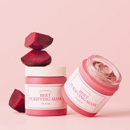 Two pink jars of purifying beet mask with fresh beetroot pieces against soft pink background