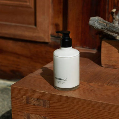 Minimalist white lotion bottle with black pump placed on warm wooden surface in natural light setting