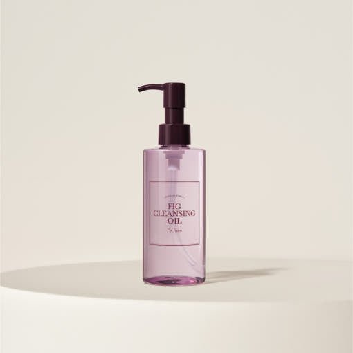 Transparent pink pump bottle of gentle cleansing oil displayed on neutral beige background with soft shadow beneath