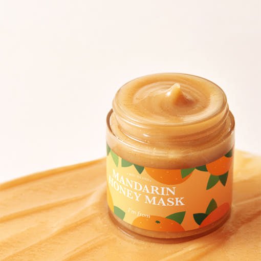Open jar of creamy mandarin honey mask with smooth texture on a warm yellow surface promoting vitalizing hydration