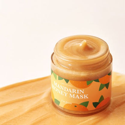 Open jar of creamy mandarin honey mask with smooth texture on a warm yellow surface promoting vitalizing hydration