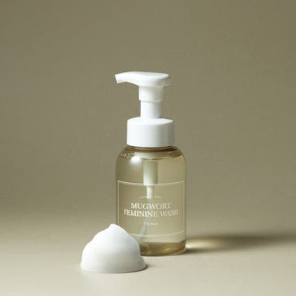 Clear bottle of gentle feminine wash with white pump and soft foam on neutral background highlighting soothing formula