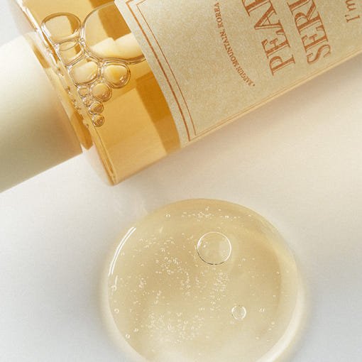 Clear gel serum drop with visible bubbles beside amber bottle highlighting hydration boost benefits
