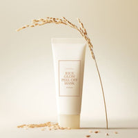 Minimalist tube of rice glow peel off mask with dried rice stalk and grains on neutral beige background