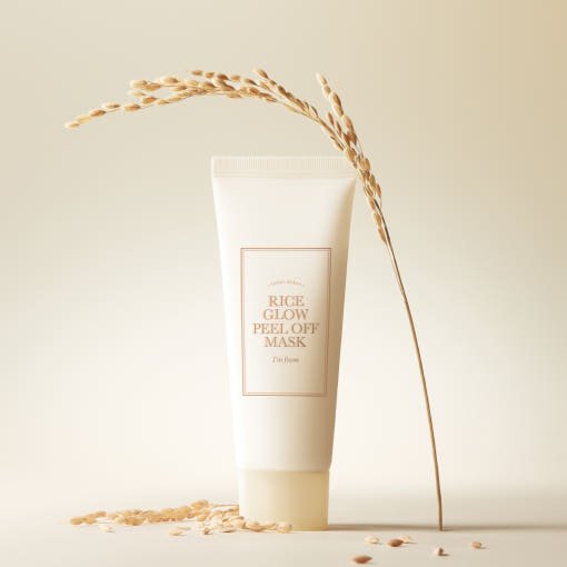 Minimalist tube of rice glow peel off mask with dried rice stalk and grains on neutral beige background