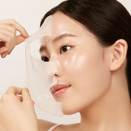 Woman gently peeling off a translucent mask revealing smooth, glowing skin with enhanced elasticity and radiance