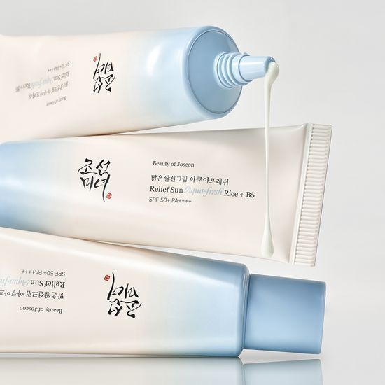 Two gradient blue and white tubes of hydrating sun protection cream with smooth white texture dripping from one tube tip