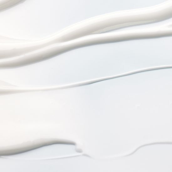 Smooth white and pale blue cream textures spread on a light background emphasizing hydration and freshness
