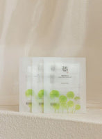 Set of calming sheet masks with green centella asiatica leaf illustrations on soft neutral backdrop