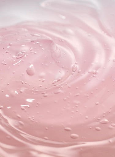 Close-up of smooth, glossy pink gel texture with small bubbles, highlighting refreshing hydration qualities