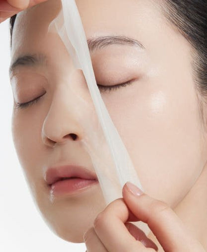 Woman applying a hydrating facial sheet mask for intense skin hydration